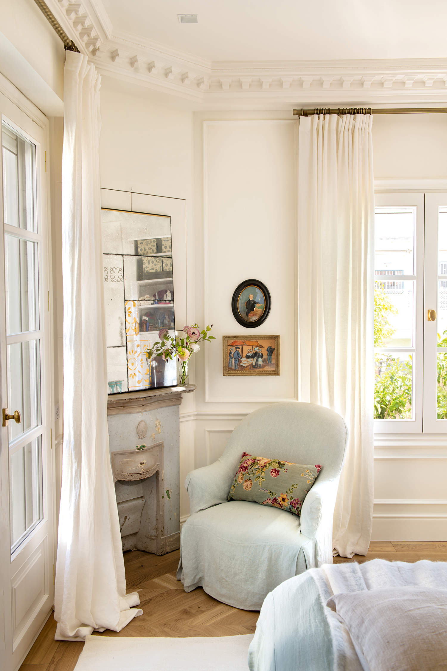 Dormitorio clásico con chimenea romántica, espejo envejecido y butaca tapizada